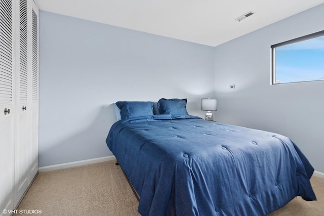 bedroom featuring carpet floors, a closet, visible vents, and baseboards