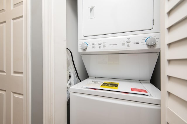 clothes washing area featuring stacked washer and dryer and laundry area