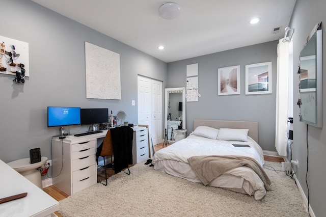 bedroom with recessed lighting, visible vents, baseboards, light wood-style floors, and a closet