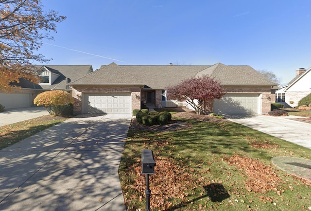 view of front of house featuring driveway, brick siding, an attached garage, and a shingled roof