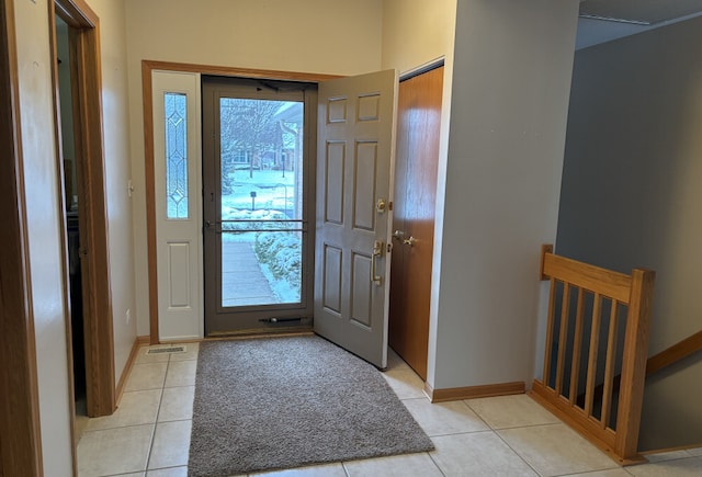 entrance foyer with light tile patterned floors and baseboards