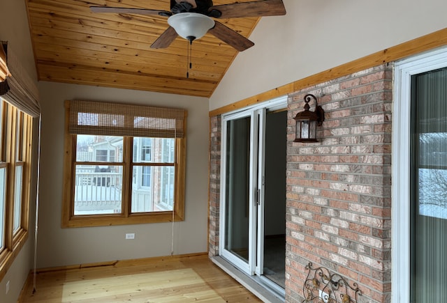 unfurnished sunroom featuring lofted ceiling, wood ceiling, and a ceiling fan