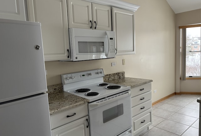 kitchen with white appliances, baseboards, light stone countertops, white cabinetry, and light tile patterned flooring