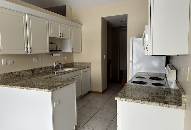 kitchen featuring light stone counters, light tile patterned flooring, white appliances, a sink, and white cabinets