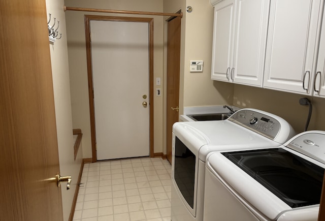 washroom featuring a sink, cabinet space, and washer and dryer