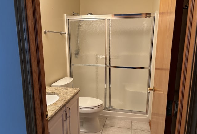 full bath featuring tile patterned flooring, a shower stall, toilet, and vanity