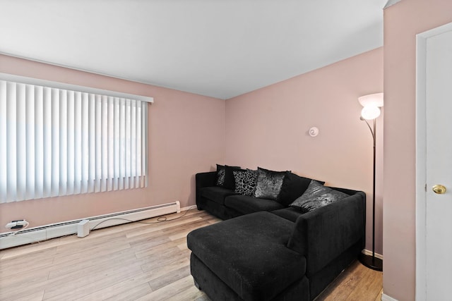 living area featuring a baseboard radiator, wood finished floors, and baseboards