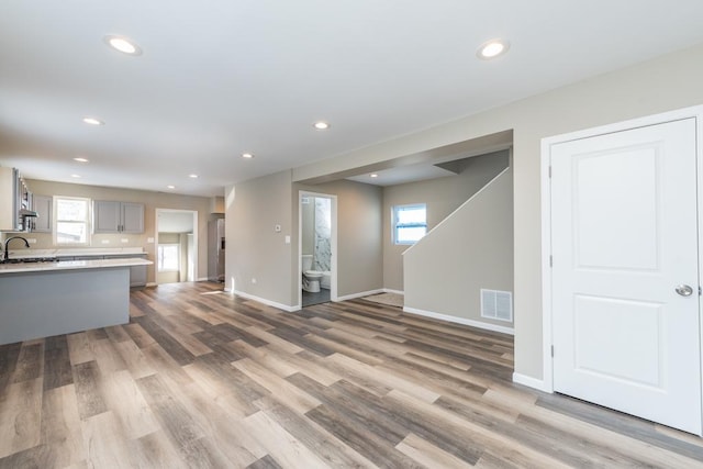 living area with light wood-type flooring, baseboards, visible vents, and recessed lighting