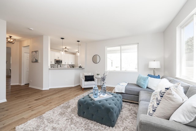 living room with a wealth of natural light, light wood-type flooring, and baseboards