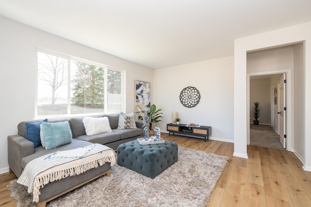 living room with baseboards and light wood-type flooring