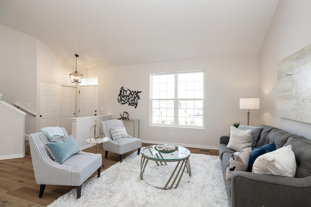 living room with baseboards, lofted ceiling, and wood finished floors