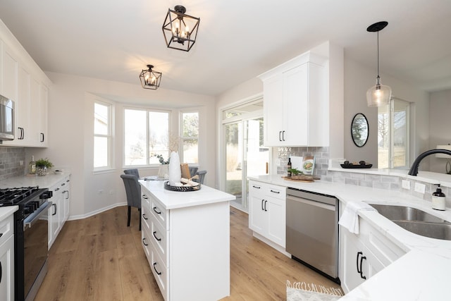 kitchen with backsplash, light wood-type flooring, range with gas cooktop, and stainless steel dishwasher