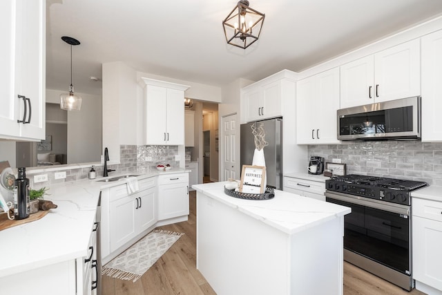 kitchen with a sink, stainless steel appliances, light wood-type flooring, and a center island