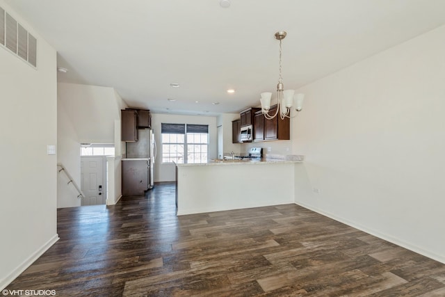 kitchen with stainless steel appliances, visible vents, dark brown cabinetry, and a peninsula