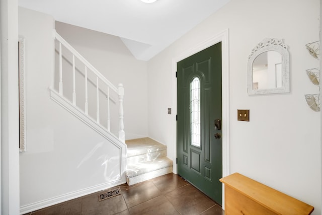 entryway with stairs and dark tile patterned floors