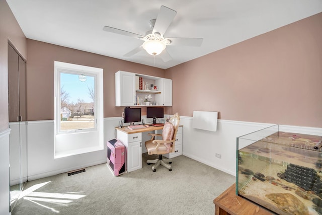 home office with a ceiling fan, visible vents, and light colored carpet