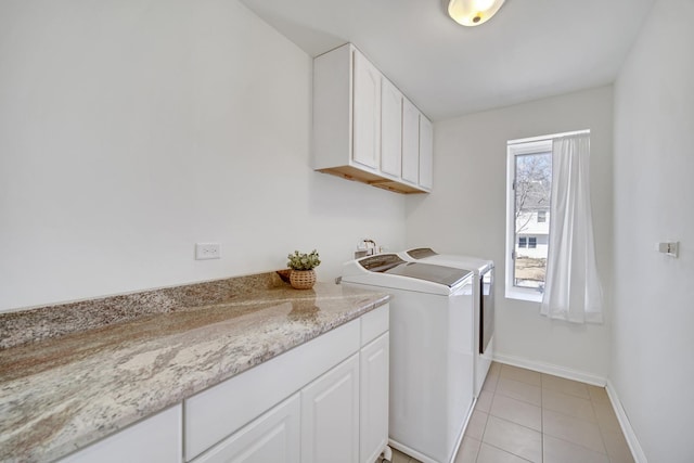 laundry room featuring light tile patterned floors, washing machine and dryer, cabinet space, and baseboards