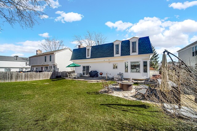 back of house with a patio, mansard roof, a shingled roof, fence, and a yard