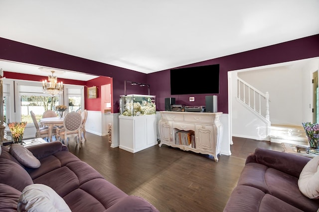 living area with dark wood-type flooring, stairway, and an inviting chandelier