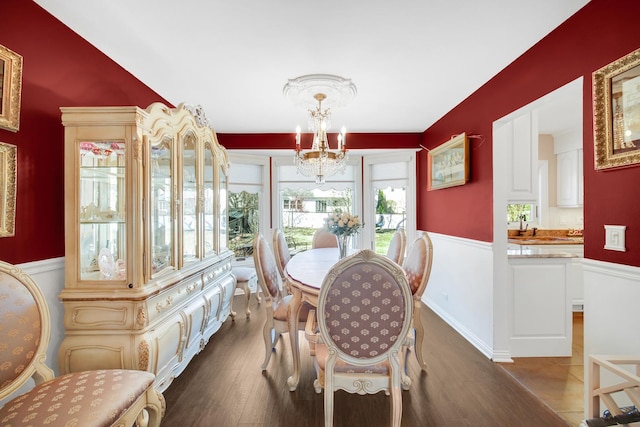 dining space with dark wood-style flooring and a notable chandelier