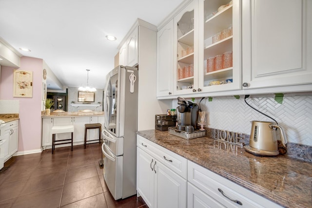 kitchen featuring glass insert cabinets, freestanding refrigerator, and white cabinets