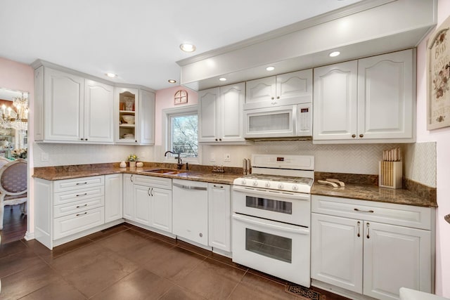 kitchen featuring white appliances, decorative backsplash, glass insert cabinets, white cabinetry, and a sink