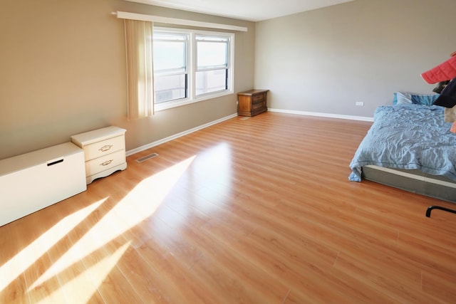 bedroom featuring light wood-style floors, baseboards, and visible vents