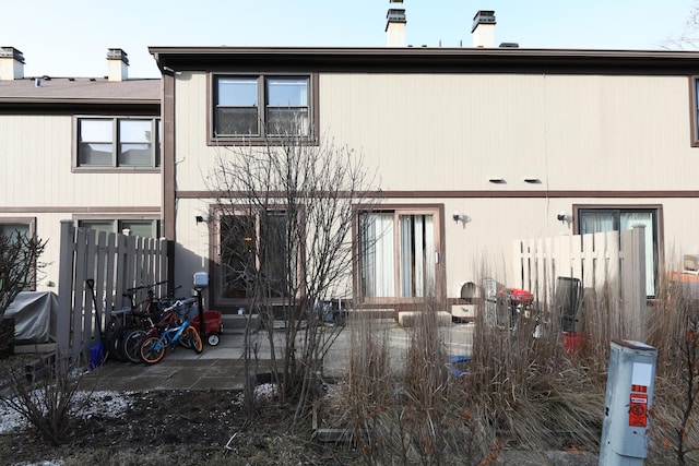 rear view of property featuring a patio area and fence