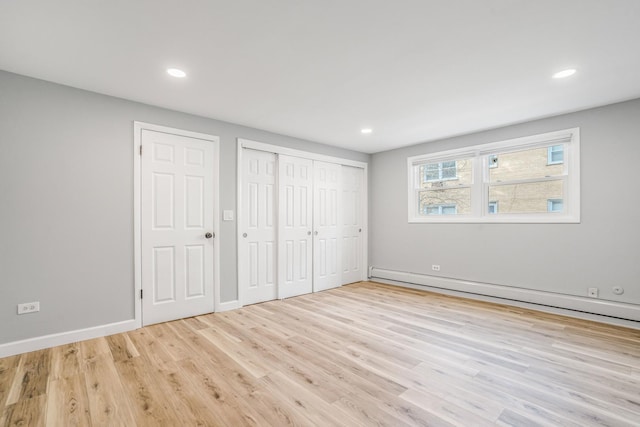 unfurnished bedroom featuring a baseboard radiator, baseboards, wood finished floors, and recessed lighting