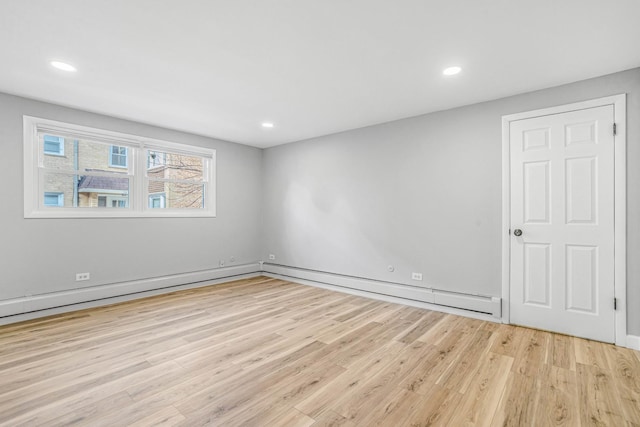 spare room with a baseboard heating unit, wood finished floors, and recessed lighting