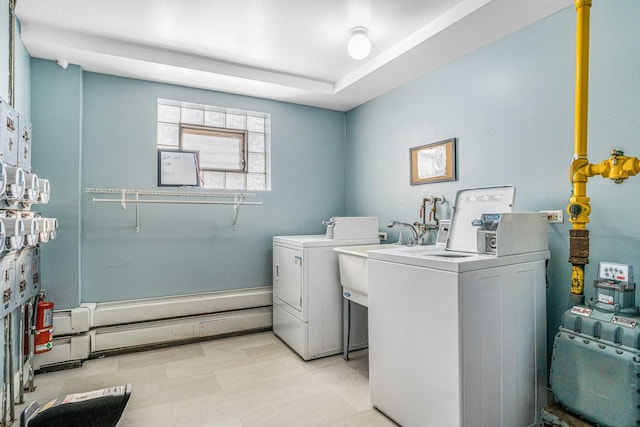 clothes washing area with washing machine and dryer and a sink