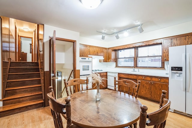 dining room with light wood-style floors and stairs