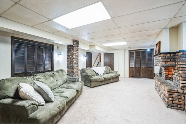 living area with a paneled ceiling, carpet, and stairs