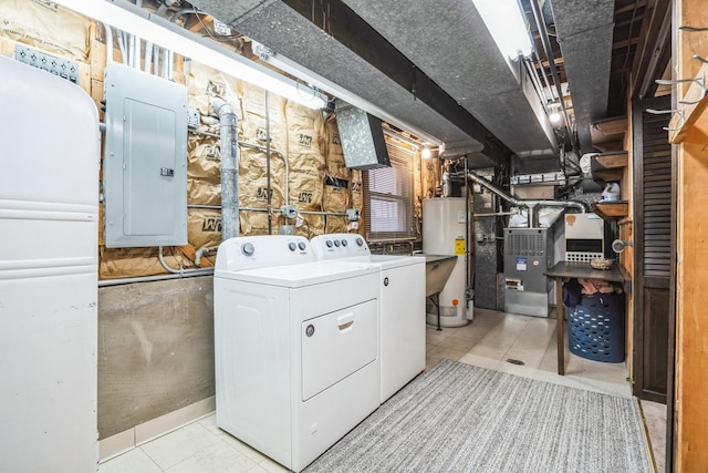 laundry room featuring gas water heater, laundry area, washer and dryer, electric panel, and tile patterned floors