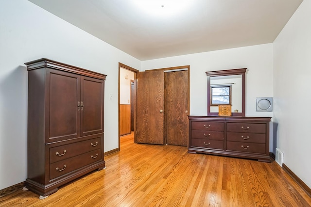 bedroom featuring light wood-style flooring, visible vents, and baseboards