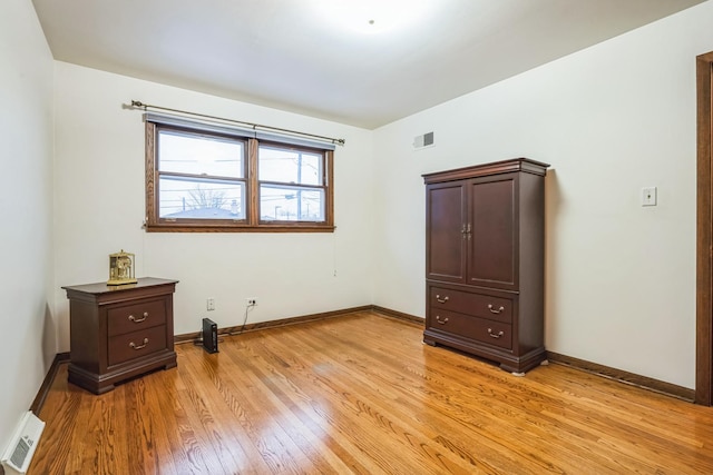 bedroom with baseboards, visible vents, and light wood-style floors