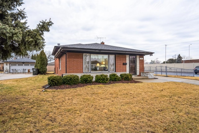 view of front of home with a front yard, fence, and brick siding