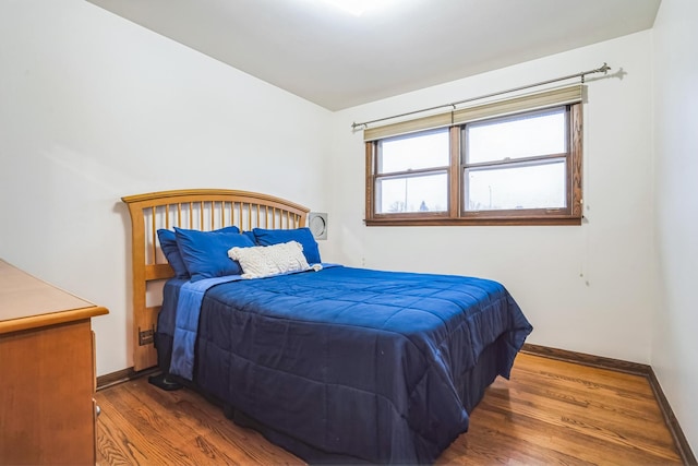 bedroom with baseboards and wood finished floors