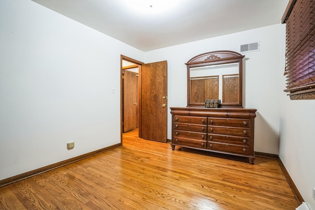 bedroom featuring visible vents, baseboards, and wood finished floors