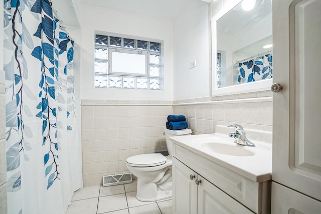 full bath featuring tile walls, visible vents, toilet, vanity, and tile patterned flooring