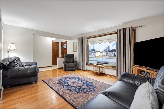 living area with light wood-type flooring and baseboards