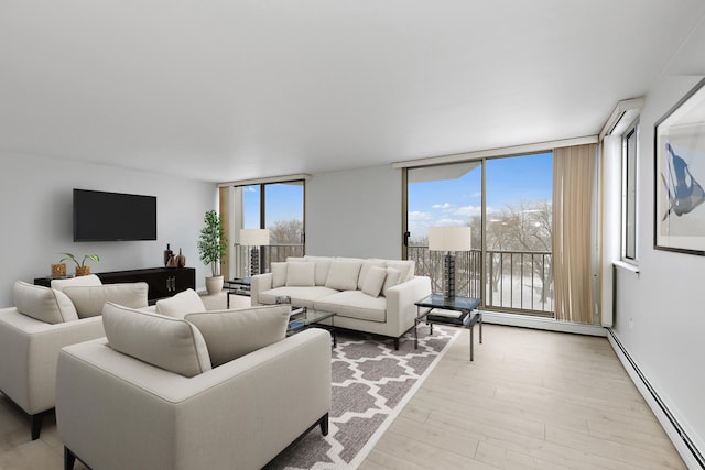 living area with light wood-style floors, a baseboard radiator, plenty of natural light, and expansive windows