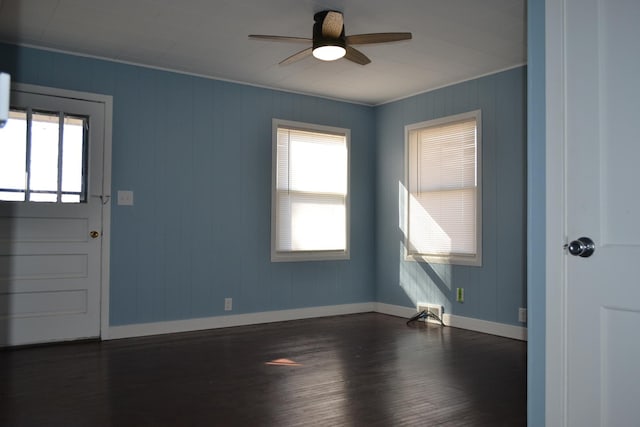 unfurnished room with ceiling fan, dark wood-type flooring, and a wealth of natural light