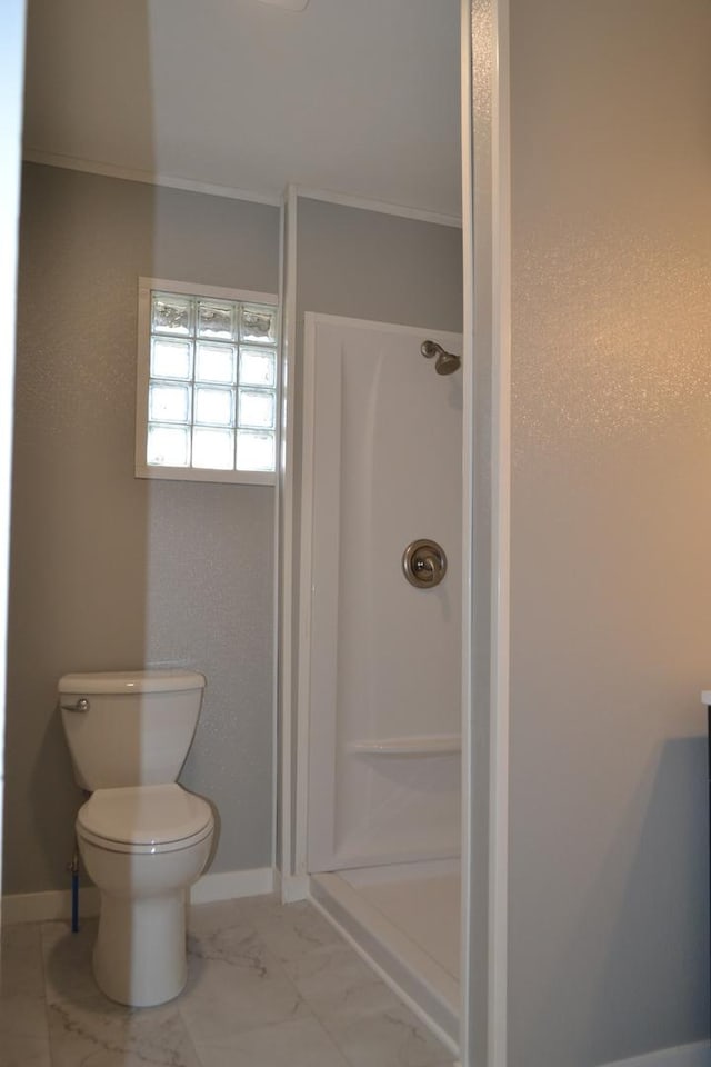 full bathroom featuring a shower stall, toilet, and baseboards