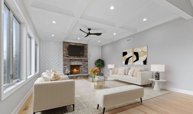 living room featuring a fireplace, visible vents, coffered ceiling, and wood finished floors