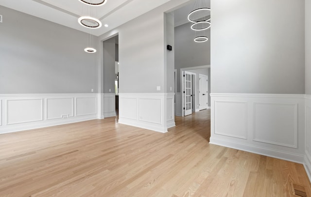 unfurnished room featuring light wood finished floors and visible vents