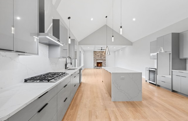 kitchen with stainless steel gas cooktop, wall chimney exhaust hood, modern cabinets, and gray cabinetry