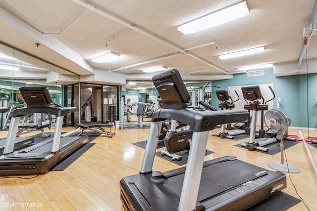 gym with wood finished floors and visible vents