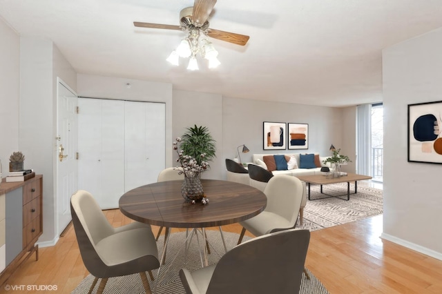 dining space with a ceiling fan, light wood-style flooring, and baseboards