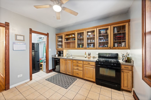 kitchen featuring light tile patterned floors, glass insert cabinets, baseboard heating, black appliances, and a sink